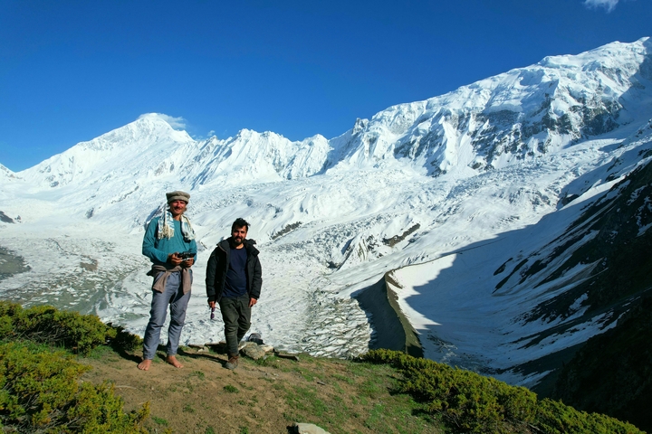       People standing in front of snow-covered mountains.
  