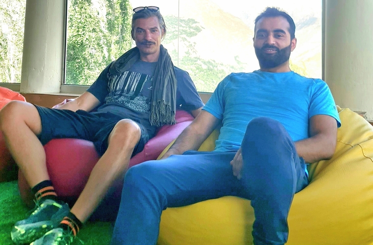 Two people sitting on bean bags in a relaxed posture.