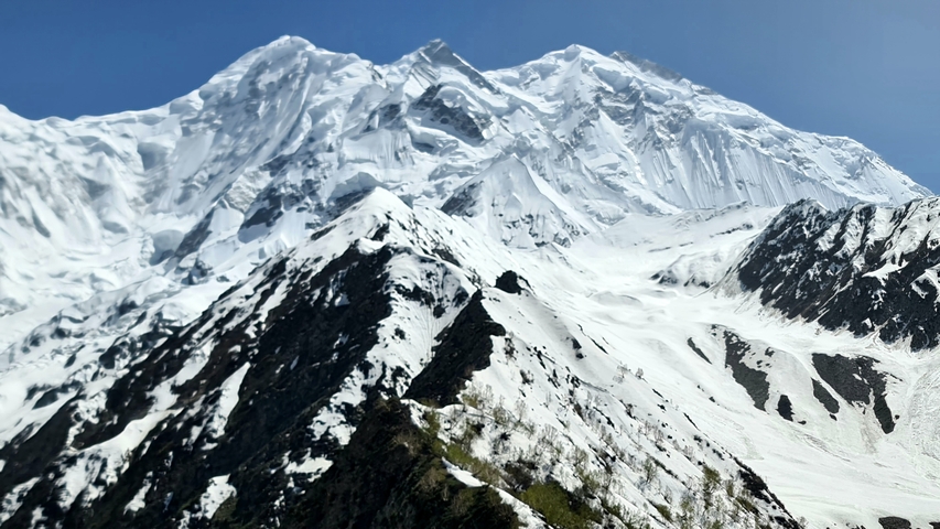       Snow-covered mountains under a clear blue sky.
  