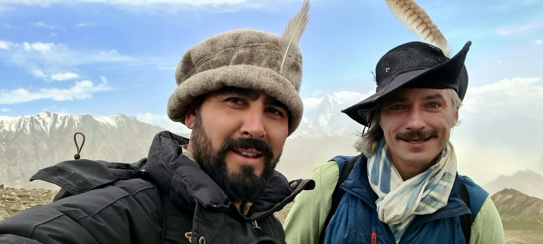 Two people wearing traditional hats posing together.