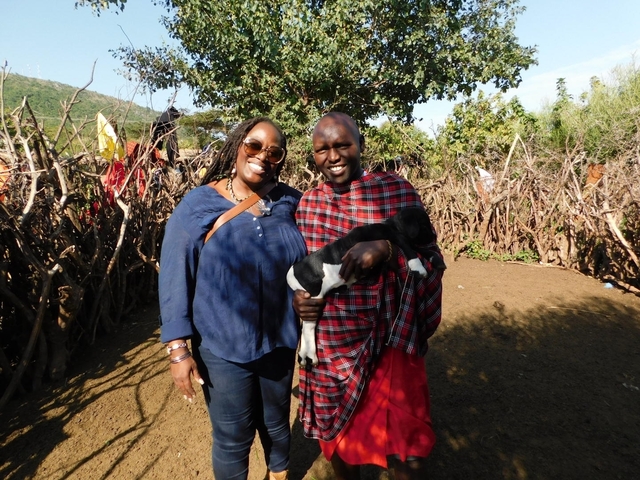       Two people posing together, one dressed in traditional Maasai clothing.
  