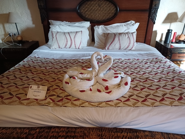 Neatly arranged bedroom with towel art on the bed.