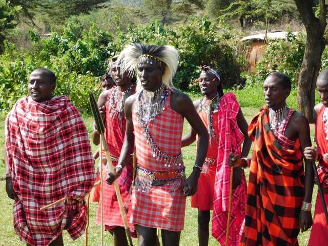 Maasai men performing traditional dance in tribal attire.