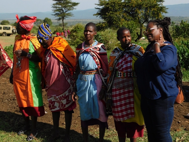 Women in traditional Maasai attire standing outdoors.