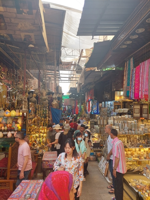       Busy market street with various goods and people.
  