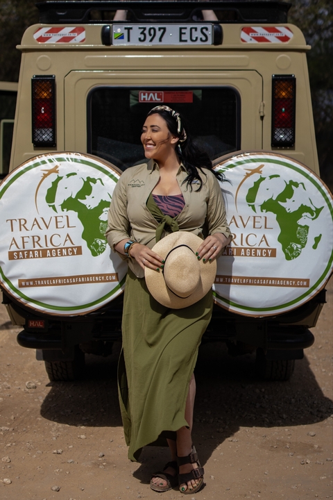 Person standing in front of a safari agency logo.