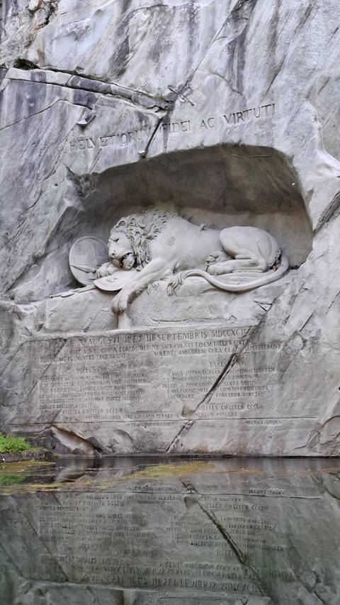 Lion monument carved into a rock wall.