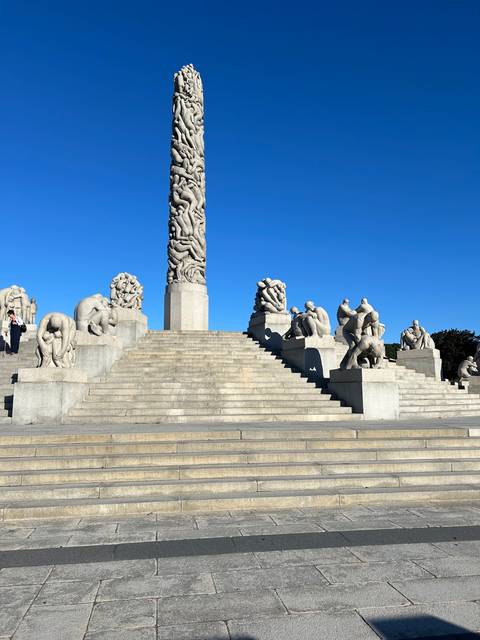       Monolith sculpture surrounded by stairs in a park.
  