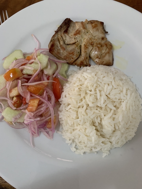       Plate of rice and salad with cooked meat.
  
