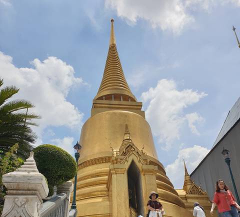       A golden pagoda with a blue sky and clouds.
  