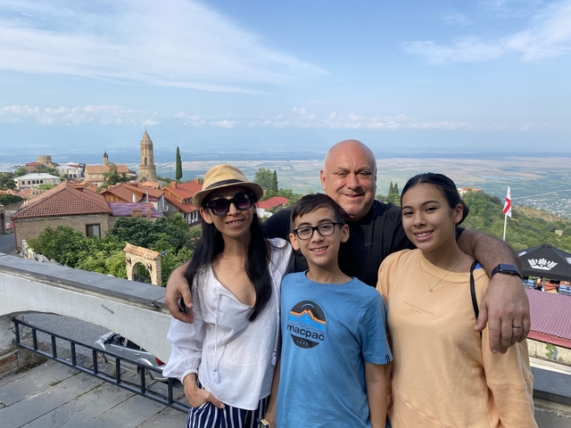 Family posing with a scenic town in the background.