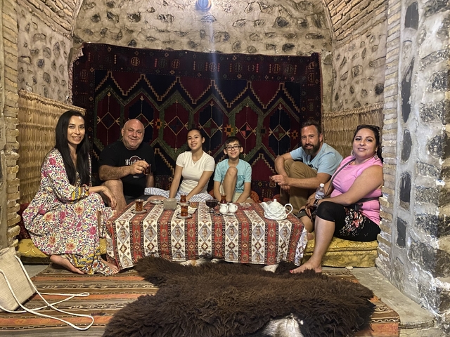       Family enjoying a traditional setting with carpets.
  