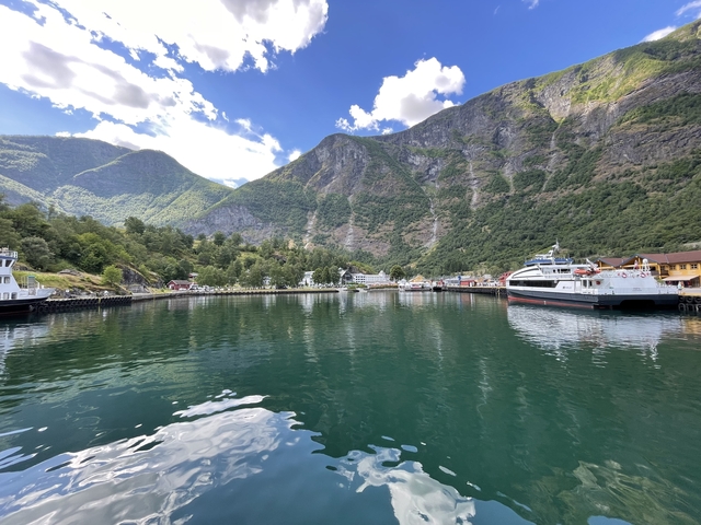 A harbor with boats and mountainous terrain in the background.