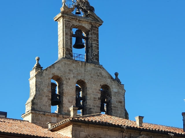 Bell tower of a historic building against a clear blue sky.