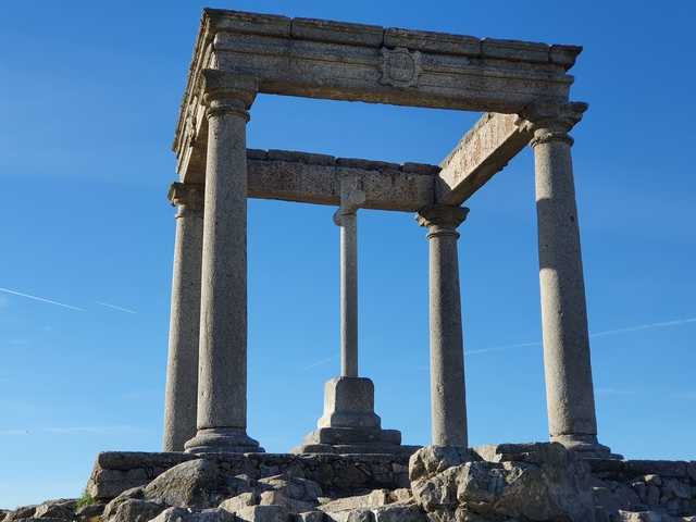 Ancient stone columns standing against a clear blue sky.