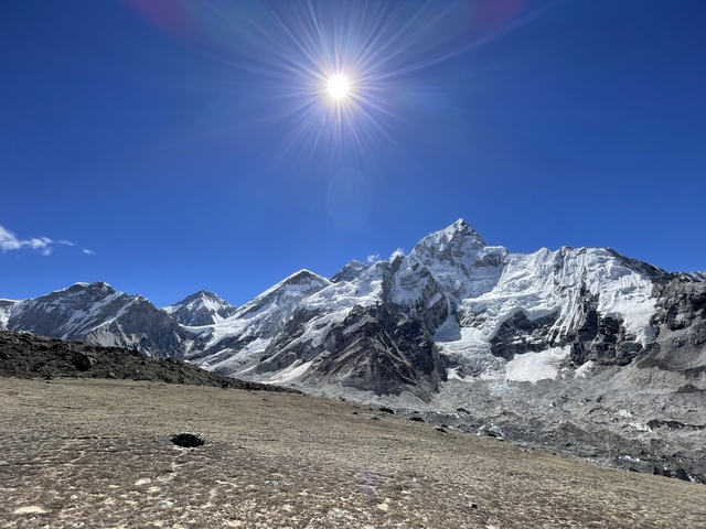 Snow-topped mountains under a bright sun.