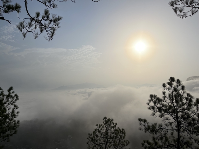 A sunrise or sunset over a foggy mountainous landscape.