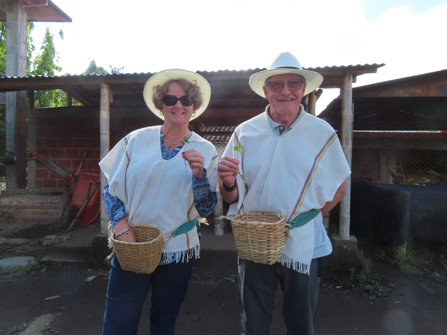       A couple holding baskets, dressed in traditional Colombian attire.
  