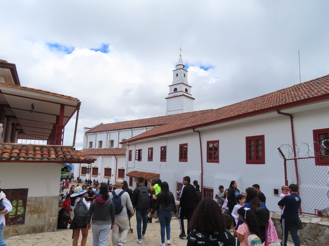       A church with people gathered in the courtyard.
  