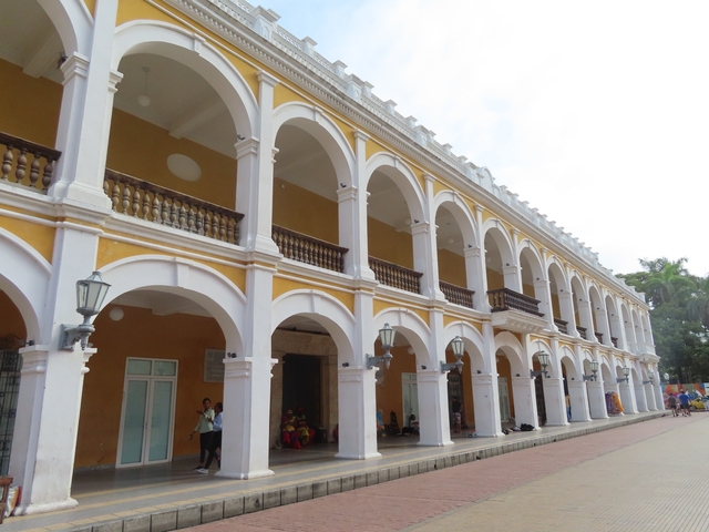       A colonial-style building with arches and yellow paint.
  