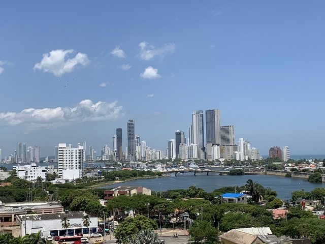       A cityscape with high-rise buildings and a body of water.
  