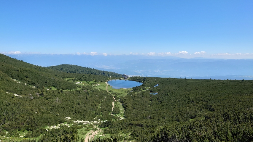 Scenic view of a mountain with a lake surrounded by lush greenery.