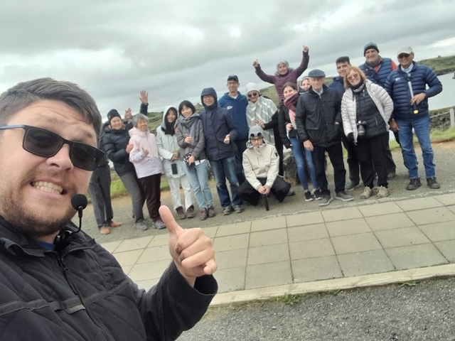       Group of people posing on a path with scenic views.
  