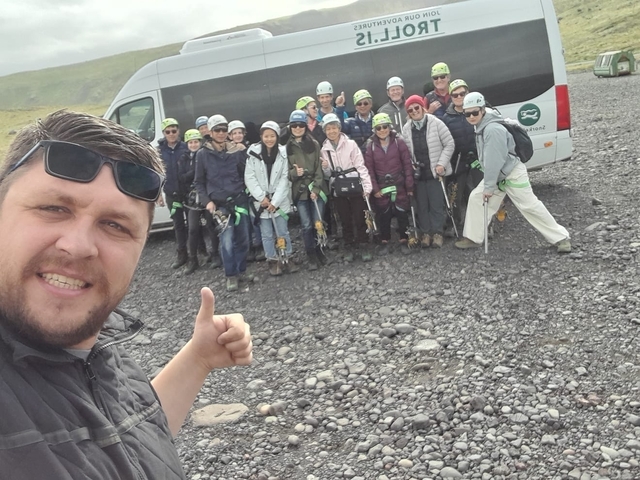       Group ready for caving adventure with helmets near a van.
  