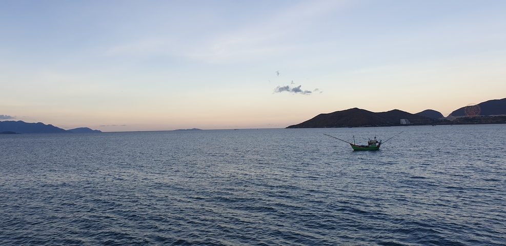 Calm sea with a distant horizon and a single boat.
