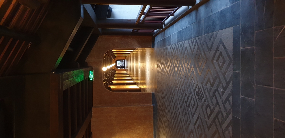 Interior hallway with patterned floor tiles and decorated ceiling.