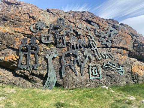       Rock face with carved artwork.
  