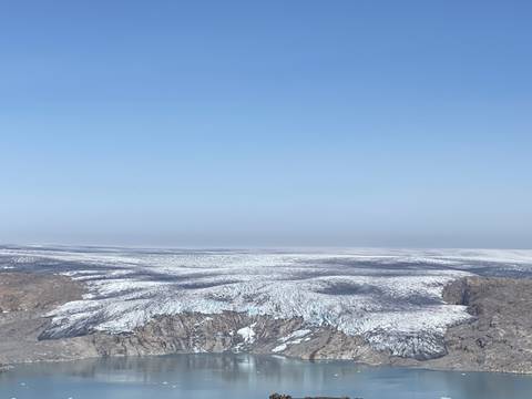       Aerial view of a vast glacier with mountains.
  