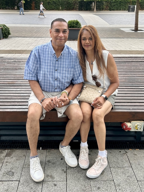 Couple sitting on a bench holding hands.