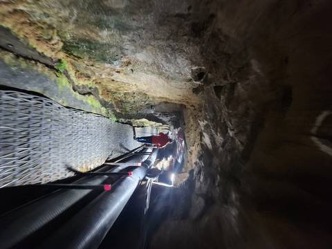 People inside an underground tunnel with lighting.