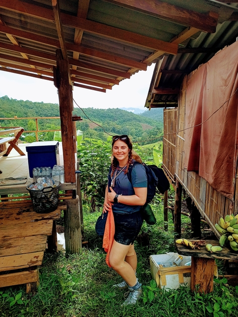 Person with a backpack in a lush green setting, possibly a hiking trail.