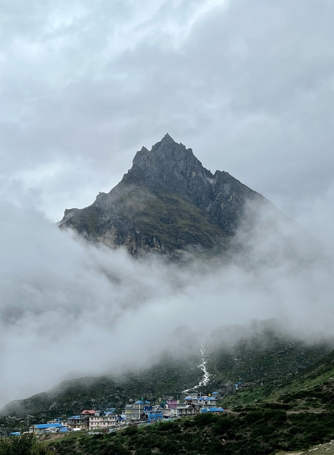 Mountain peak surrounded by clouds creating a mystical feel.
