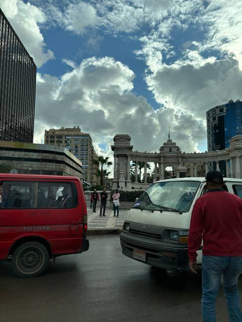 A bustling city street scene with cars and architecture.