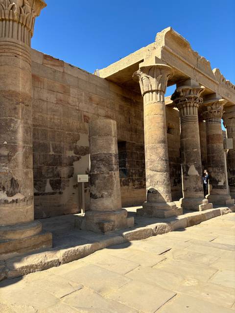 Ancient pillars and architecture under clear blue sky.