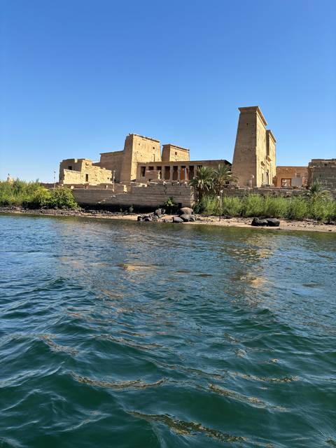       Ancient Egyptian temple ruins by the water.
  
