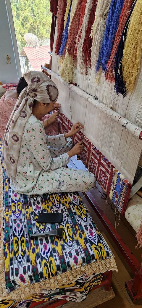 Person weaving traditional textiles on a wooden loom