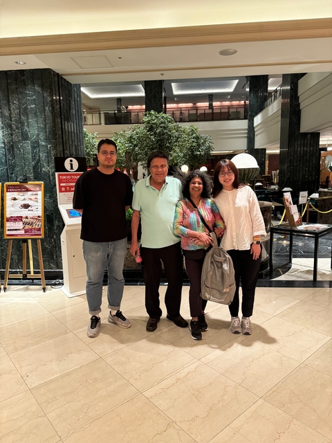 Four people standing in a lobby with information signs.