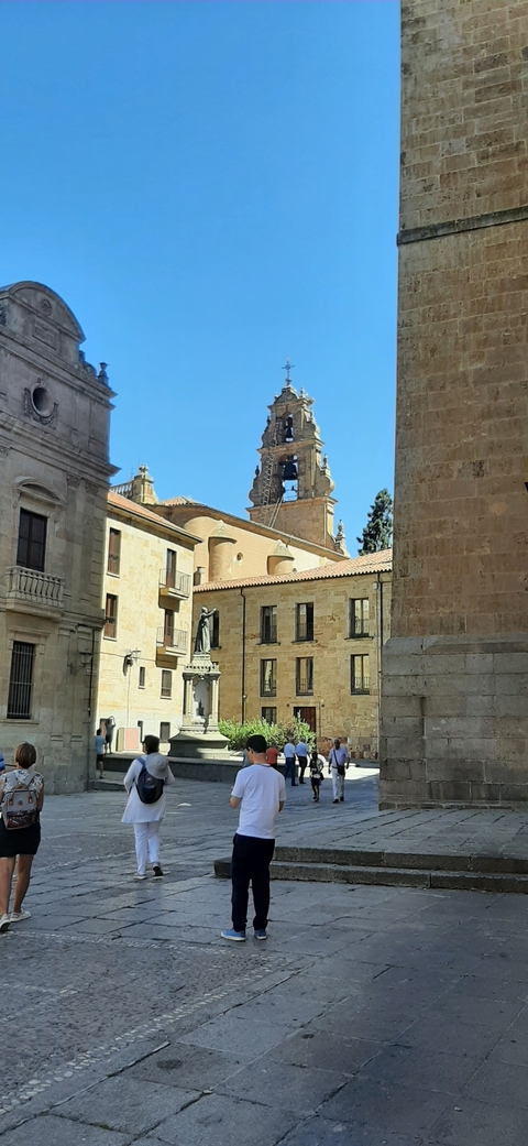       Historic buildings with bell tower in a courtyard.
  
