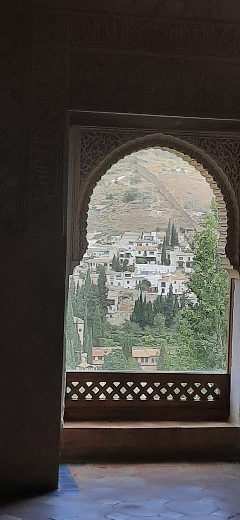       View of a town through a decorative archway.
  