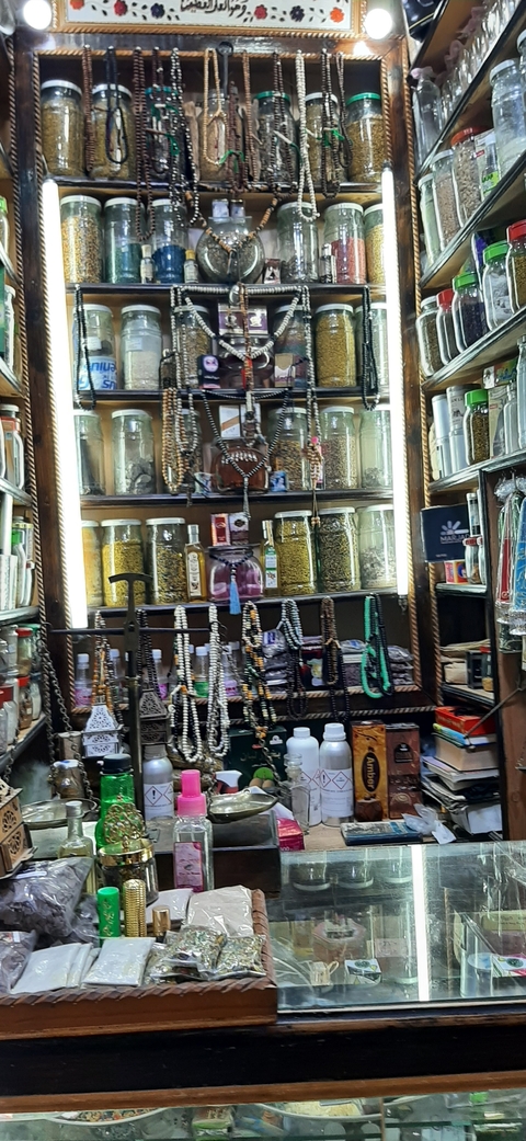 Shelves with jars, jewelry, and goods in a shop.