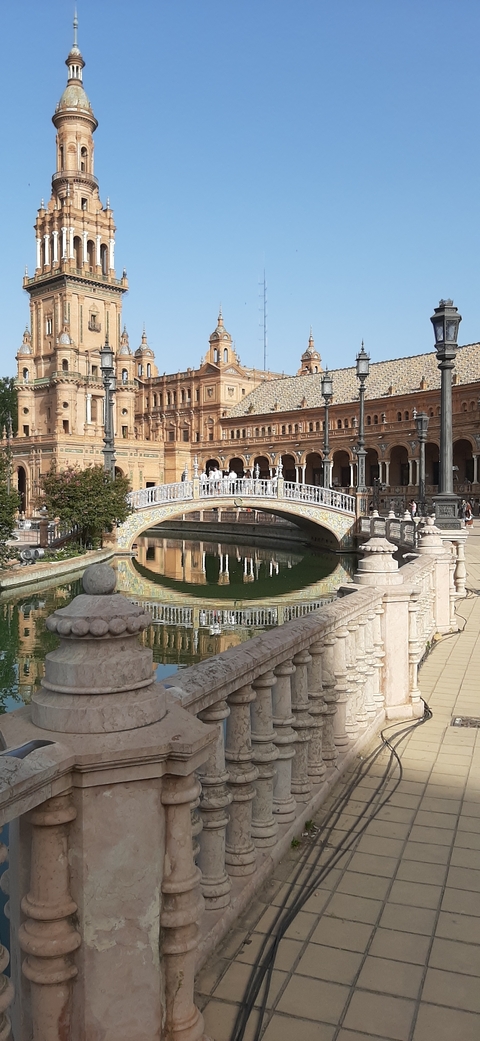       Ornate architecture and bridge with reflections on water.
  