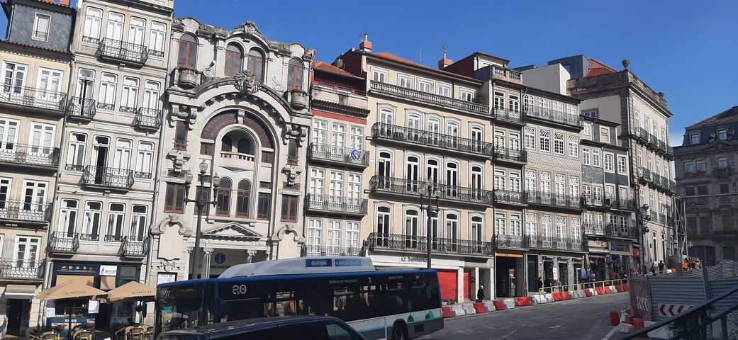       Row of historic buildings with detailed facades on a street.
  