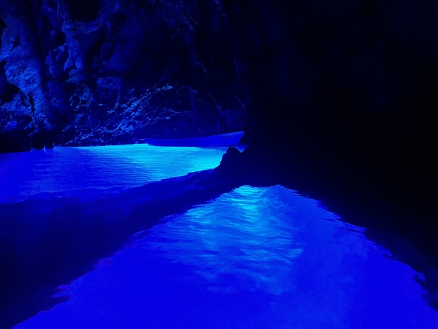 Glow of blue water in a dark cave setting.