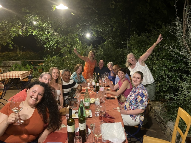 Group of people dining outdoors under lights at night.