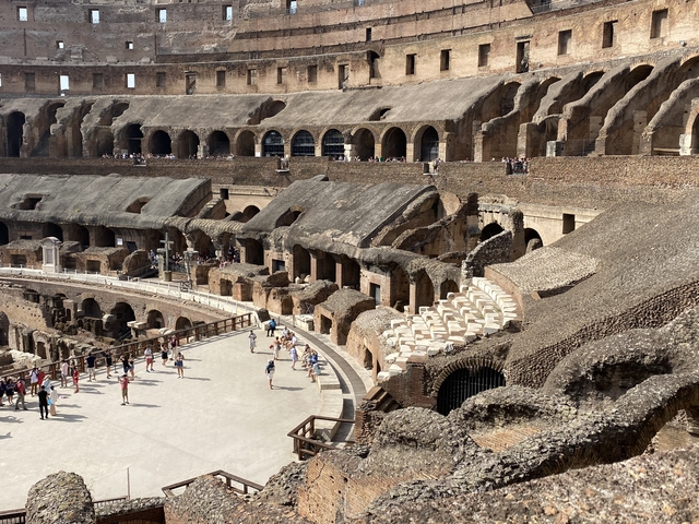       Interior view of the Colosseum with tourists.
  