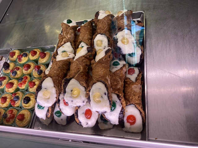       Cannoli and pastries in a display case.
  
